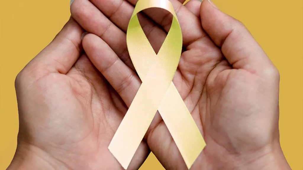 mão segurando laço amarelo