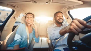 melhor proteção veicular casal de homem e mulher dentro de carro sorrindo