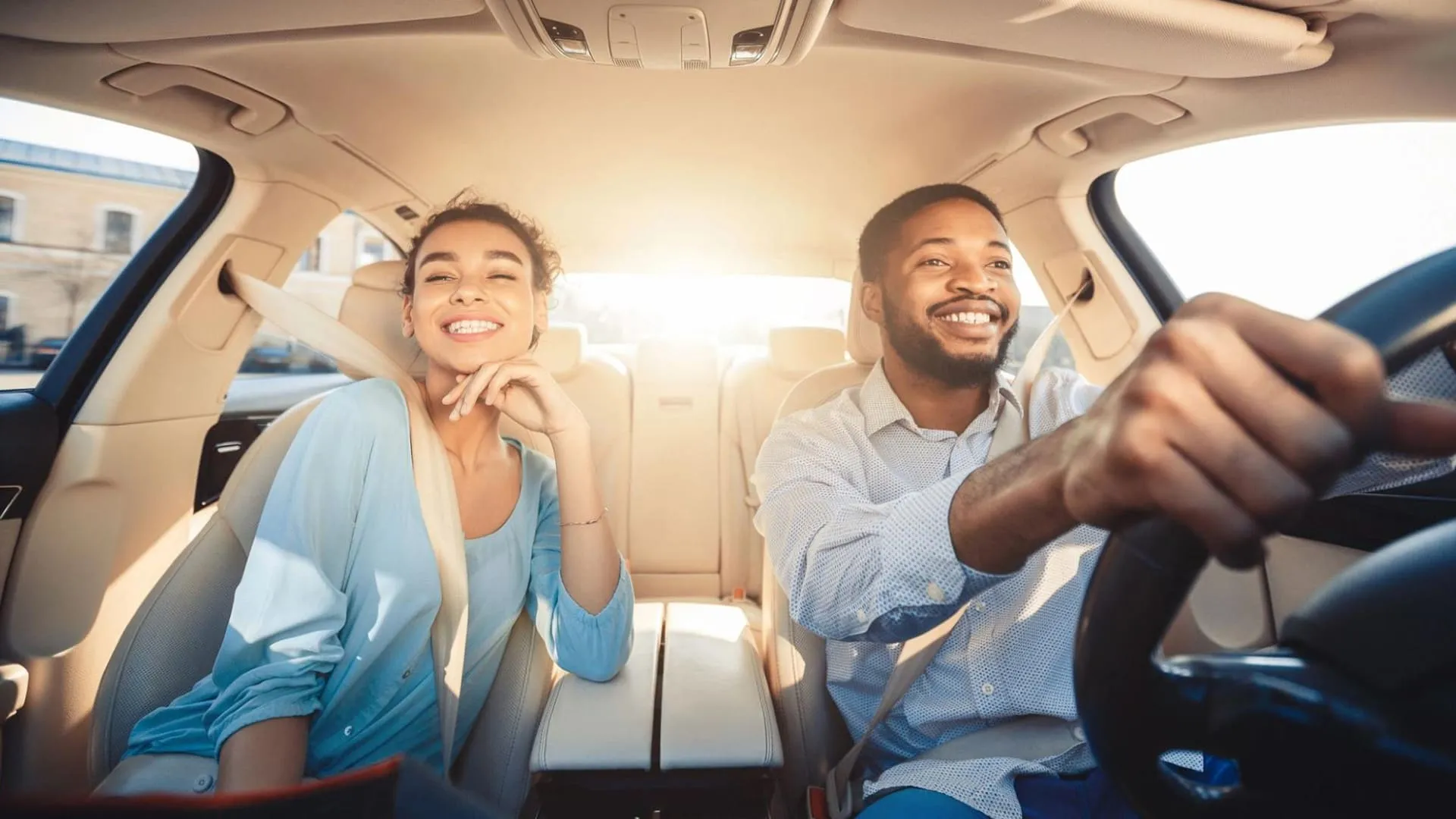 melhor proteção veicular casal de homem e mulher dentro de carro sorrindo