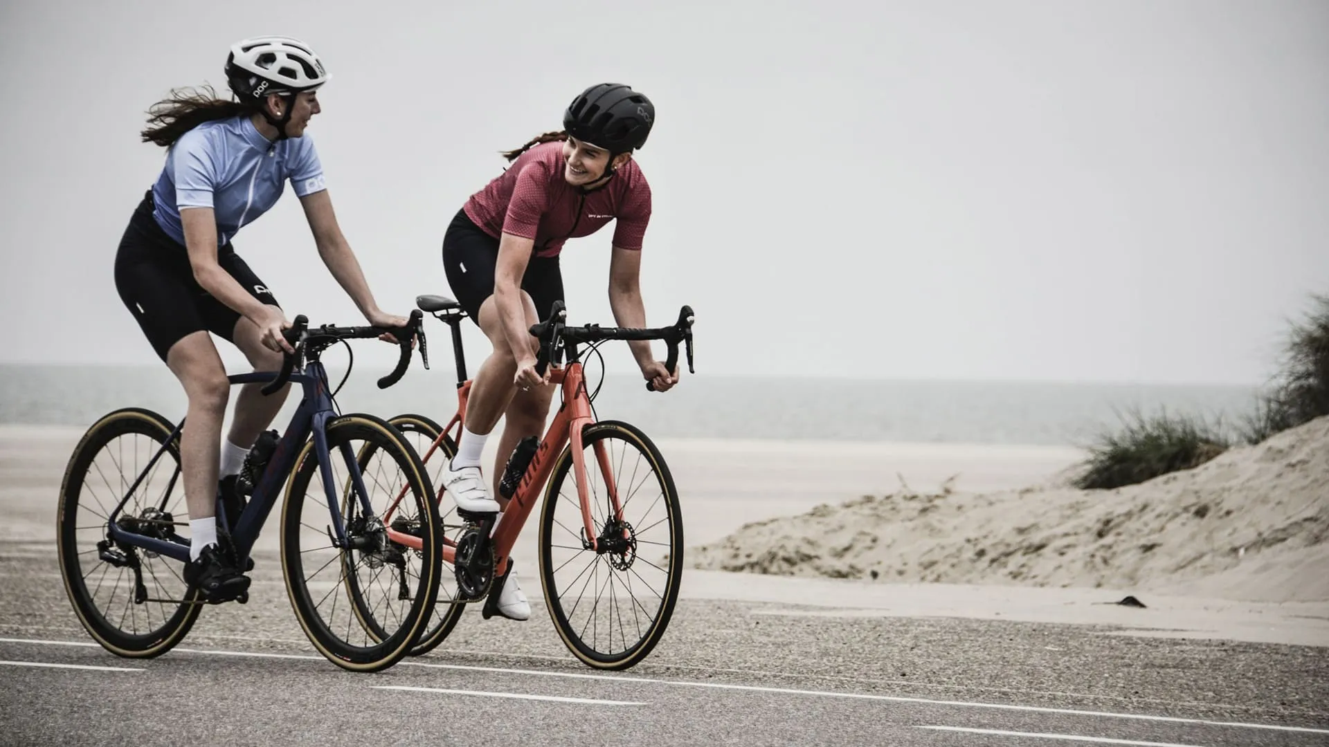 Bike duas mulheres andando de cicicleta em frente a praia