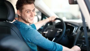 proteção veicular homem dentro do carro sorrindo para foto