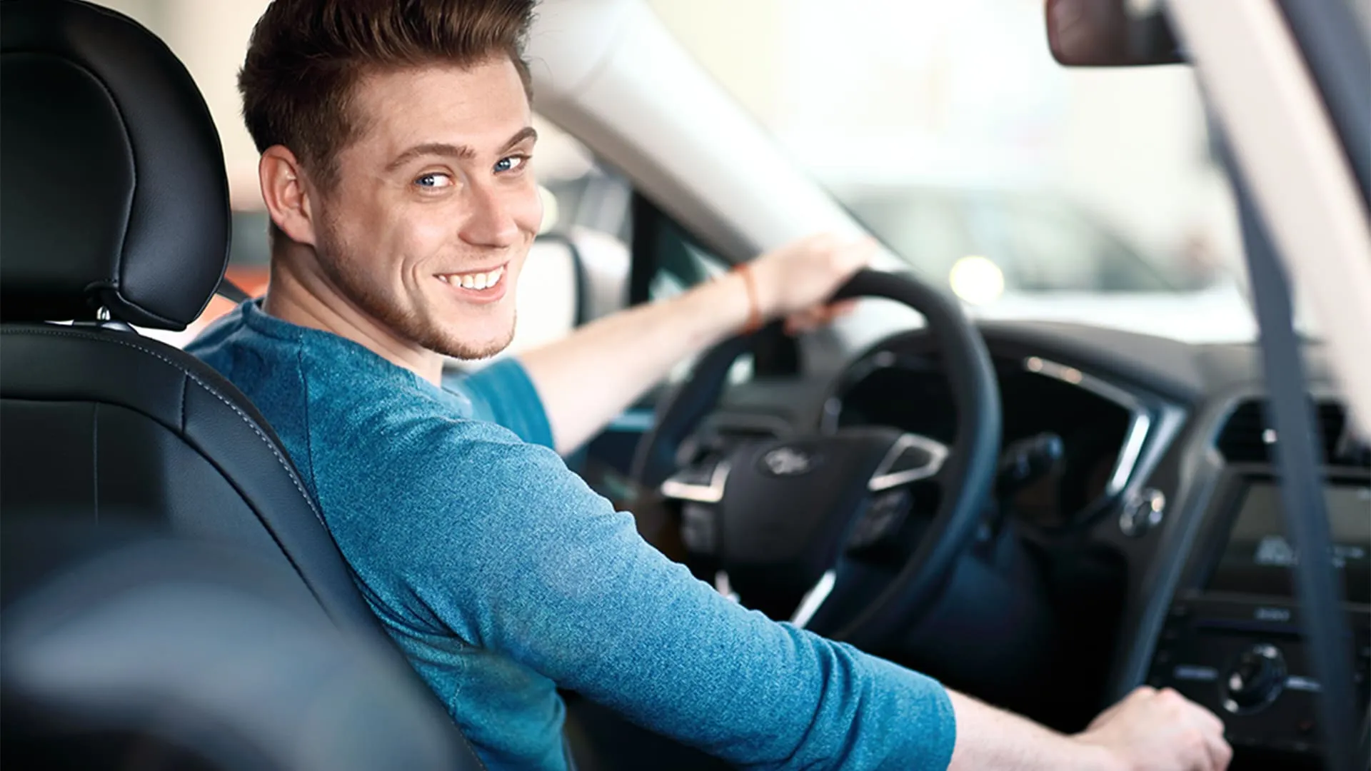 proteção veicular homem dentro do carro sorrindo para foto