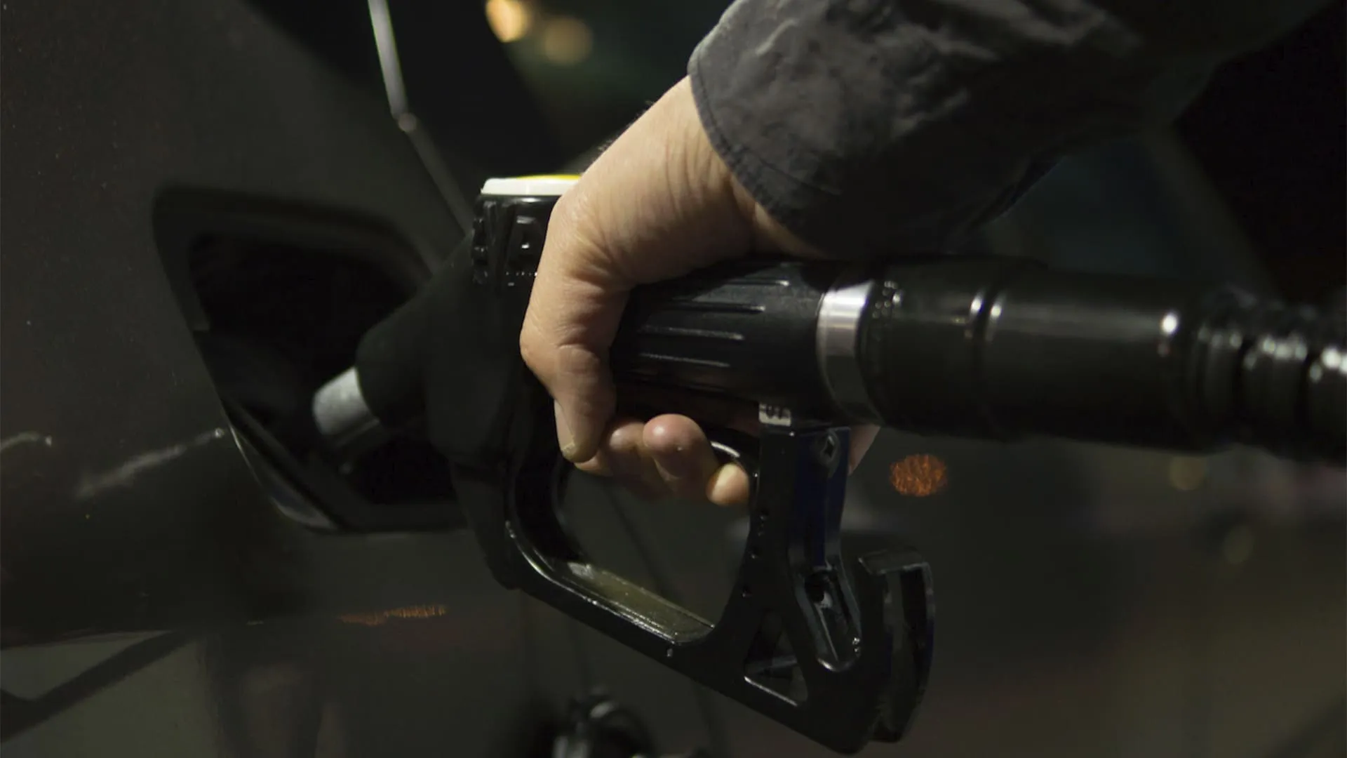 mão colocando gasolina em carro
