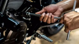 Manutenção mão com ferramenta encostando em moto