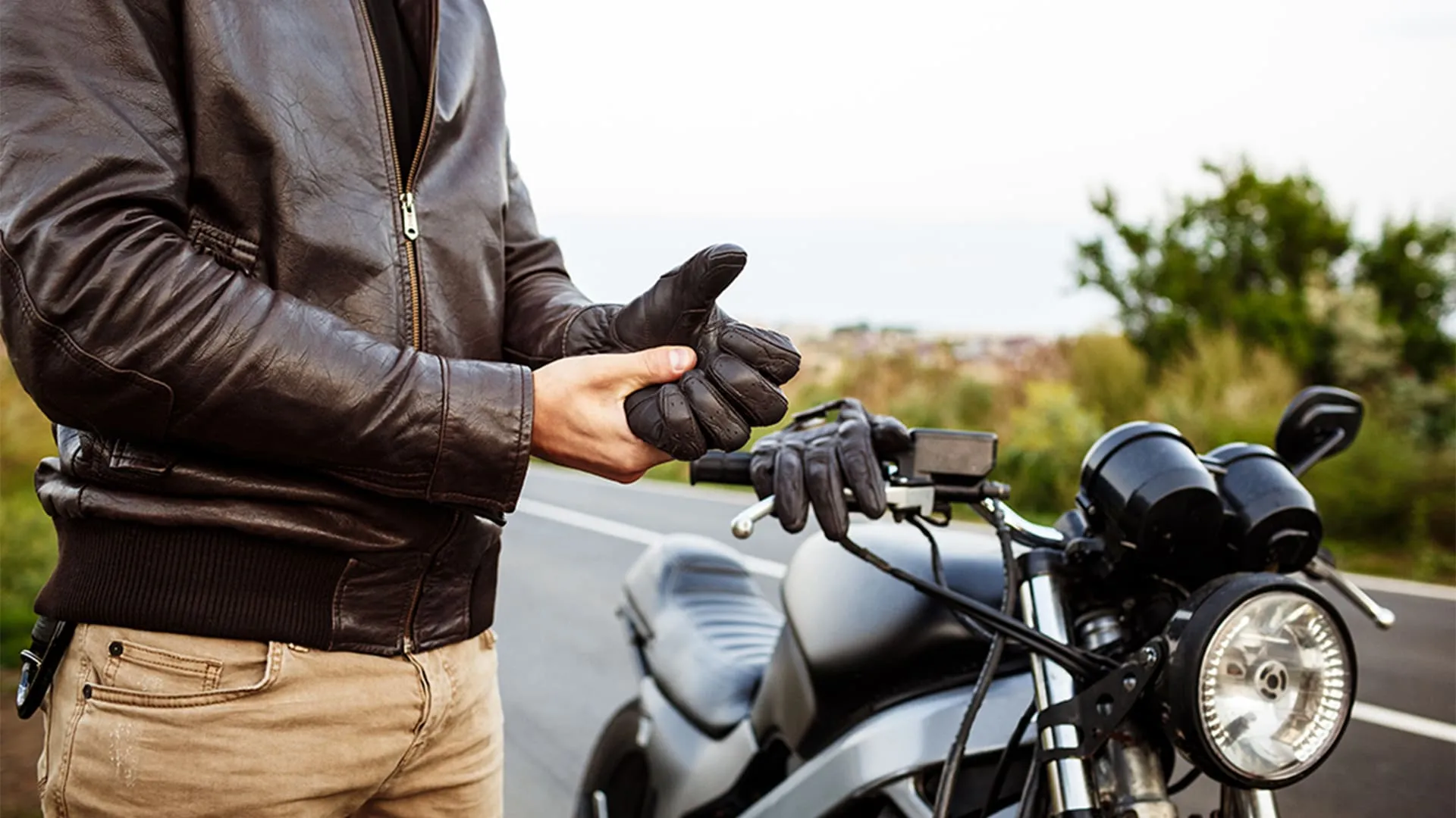 Cuidados com a moto motociclista arrumando sua luva ao lado de sua moto