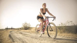 bicicletas mulher andando em biciclata em um terreno arenoso
