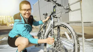 mulher lavando sua bicicleta e sorrindo