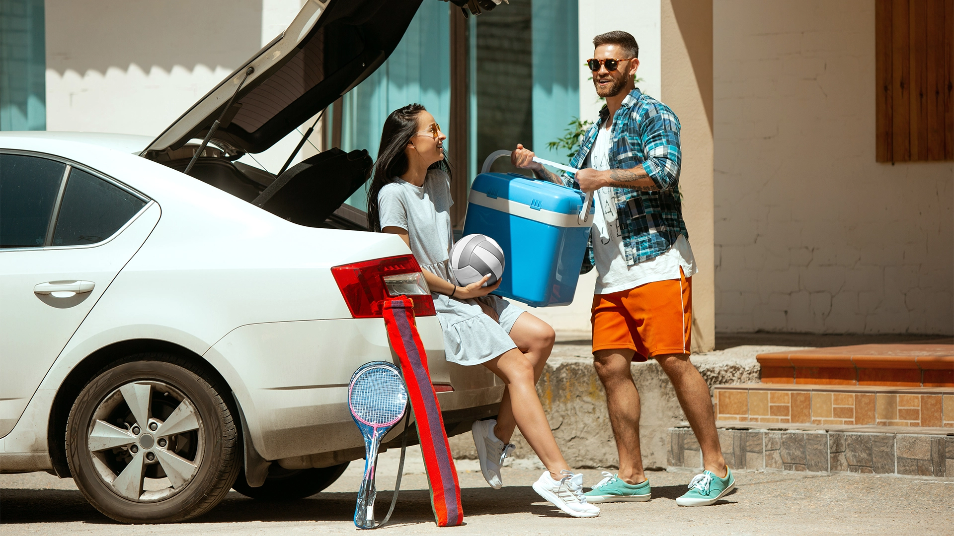 proteção veicular-jovem-casal-se-preparando-para-a-viagem-de-ferias-no-carro-em-um-dia-ensolarado-mulher-e-homem-empilhando-equipamentos-esportivos-pronto-para-ir-para-o-mar-ribeirinha-ou-oceano-conceito-de-relacio-