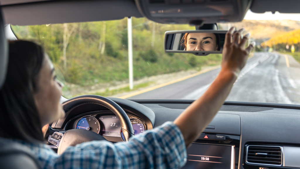 A importância da direção defensiva - mulher ajustando retrovisor